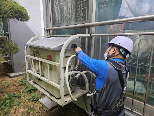서울 영등포구 관계자가 한 아파트에 에어컨 실외기 차양막을 설치하고 있다. 영등포구 제공