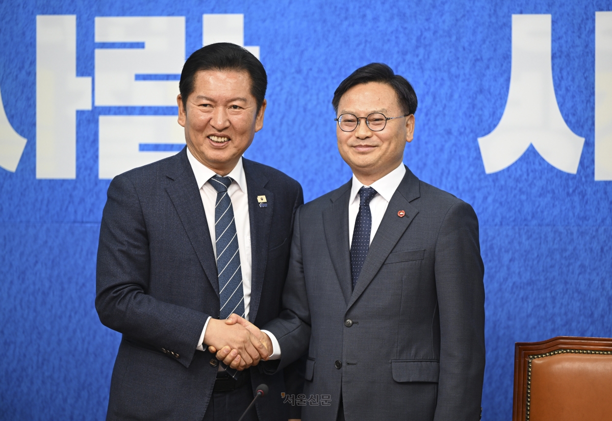 정청래(왼쪽) 더불어민주당 대표와 김성범 전 해양수산부 차관이 30일 국회에서 열린 더불어민주당 인재 영입식에서 손을 맞잡고 있다. 2026.4.30 이지훈 기자