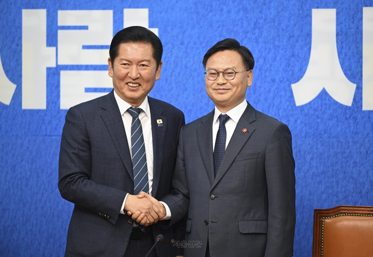 정청래(왼쪽) 더불어민주당 대표와 김성범 전 해양수산부 차관이 30일 국회에서 열린 더불어민주당 인재 영입식에서 손을 맞잡고 있다. 2026.4.30 이지훈 기자