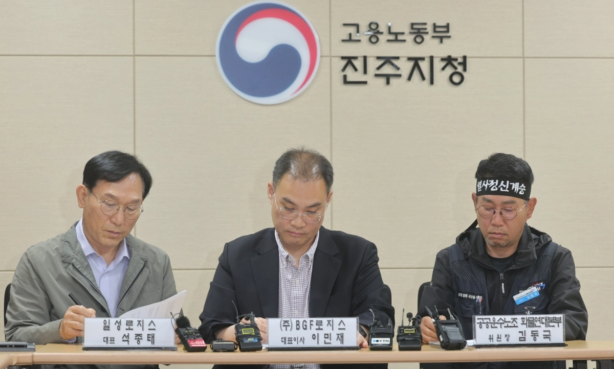 민주노총 공공운수노조 화물연대본부(화물연대) 김동국 위원장(맨 오른쪽)과 이민재 BGF 로지스 대표이사(가운데), 석종태 일성로지스 대표가 30일 오전 경남 진주시 고용노동부 진주지청에서 단체합의서에 서명하고 있다. 연합뉴스