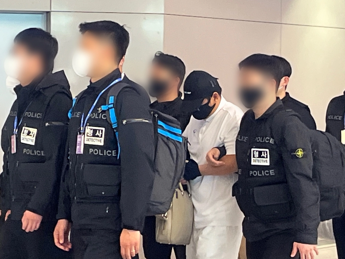 ‘마약왕’ 박왕열에게 마약을 공급한 혐의를 받는 최모(51)씨가 1일 인천국제공항 입국장에서 경찰에 호송되고 있다. 박다운 수습기자