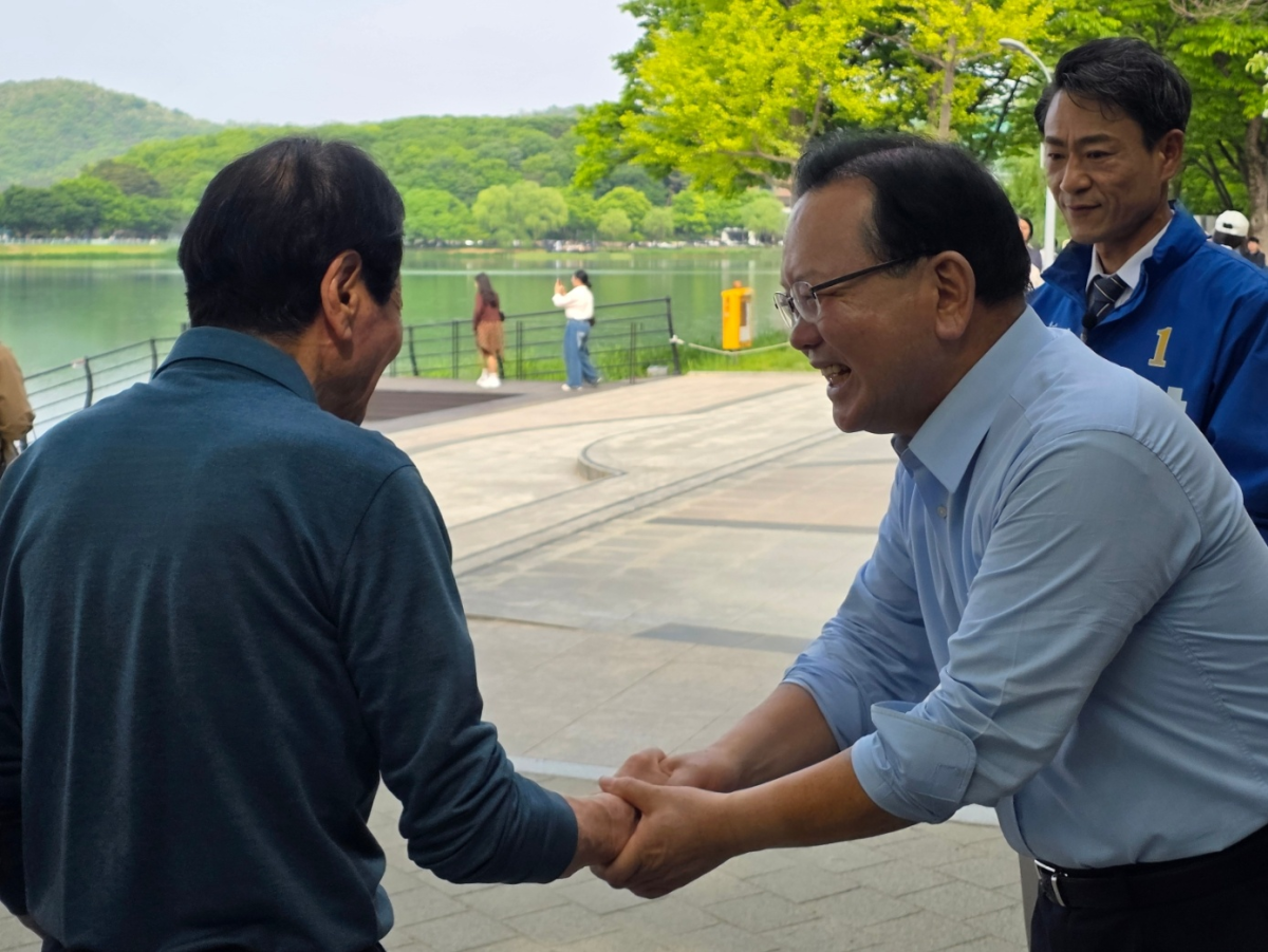 더불어민주당 대구시장 후보인 김부겸 전 국무총리가 2일 대구 수성구 두산동에 있는 수성못에서 시민과 악수를 하고 있다. 2026. 5. 2. 대구 민경석 기자