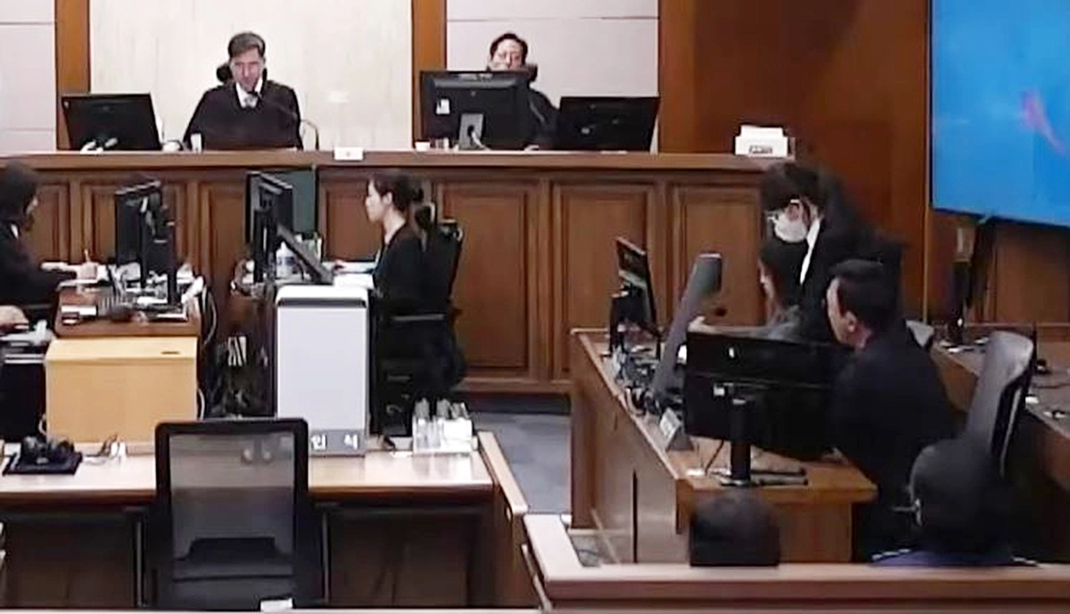 지난달 28일 김건희 항소심을 진행하고 있는 신종오(사진 위 왼쪽) 서울고법 판사. 김 여사가 마스크와 안경을 쓴 채 일어나 고개를 숙인 자세로 재판부의 형량 선고를 듣고 있다. 서울중앙지법 제공