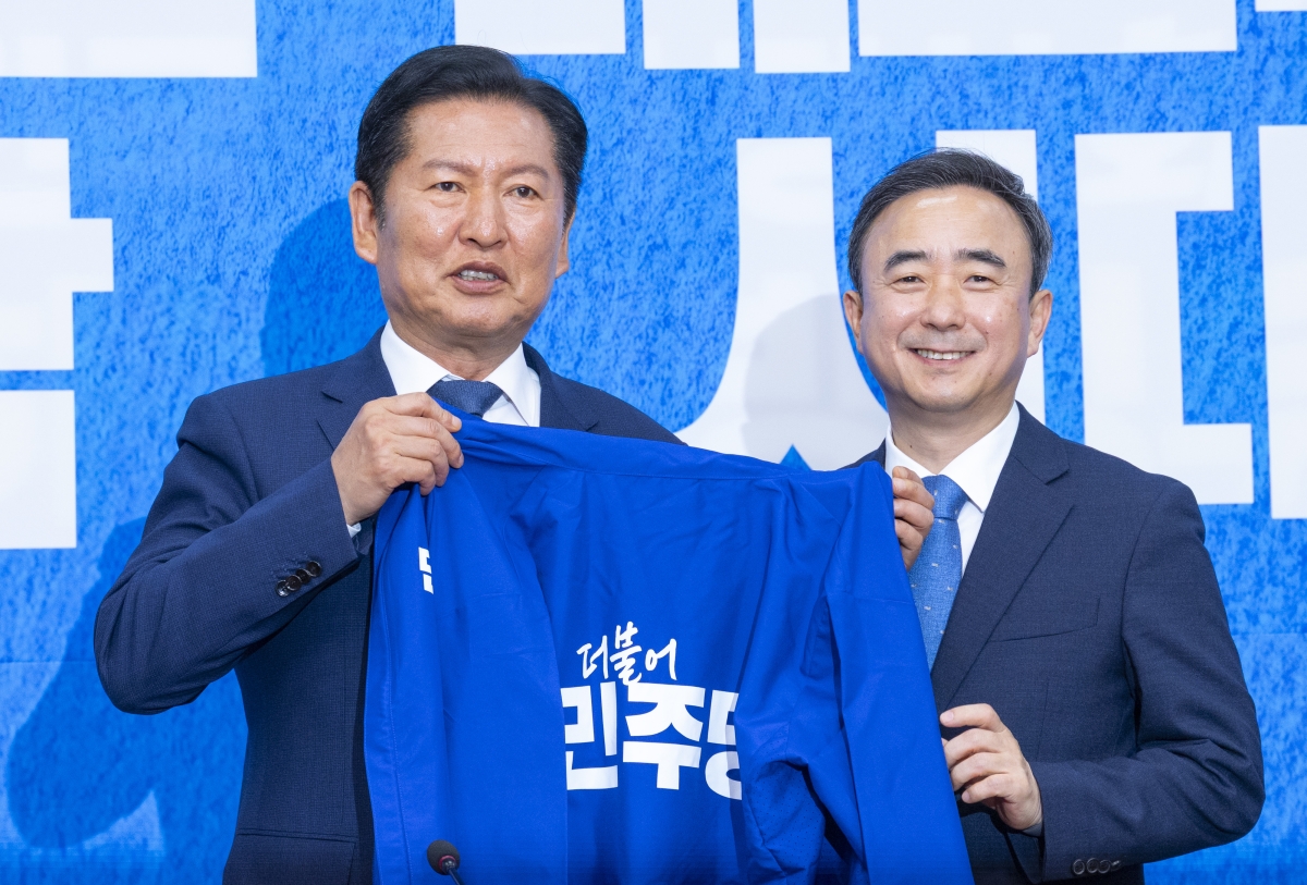 임문영 AI전략위원회 상근부위원장(오른쪽)이 지난 6일 국회에서 열린 민주당 인재 영입식에서 정청래 대표에게서 민주당 상징인 ‘파란 점퍼’를 전달받고 있다. 연합뉴스 제공
