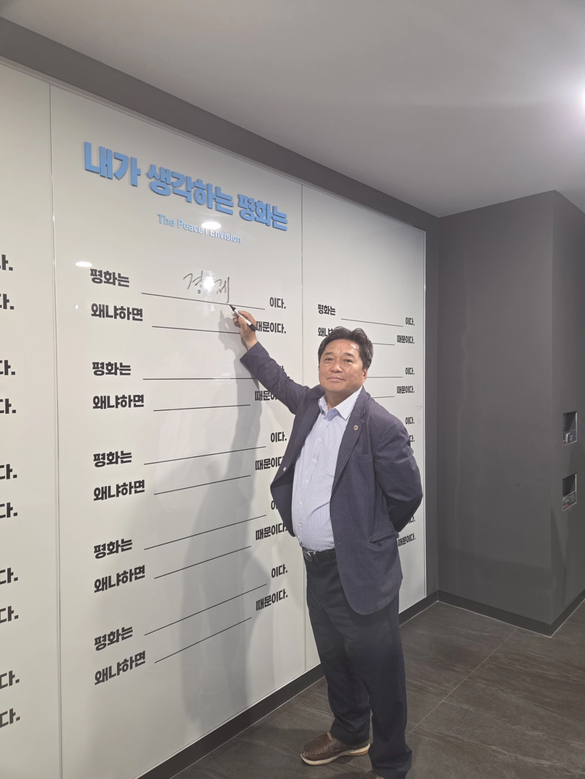 김호겸 의원이 파주 미래통일교육센터 통일교육 체험관에서 ‘내가 생각하는 평화는’ 게시판에 “경제”라고 직접 적으며 평화에 대한 자신의 견해를 밝히고 있다. (사진=경기도의회)