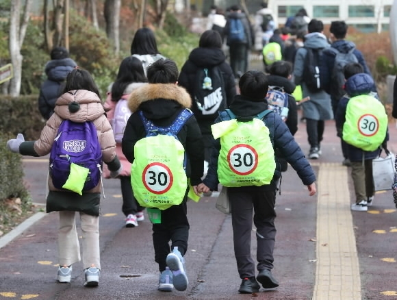 2022년 12월 13일 서울 강남구의 한 초등학교 앞에서 학생들이 ‘스쿨존 입니다’ 글귀가 적힌 안전 가방을 메고 등교하고 있다. 뉴스1