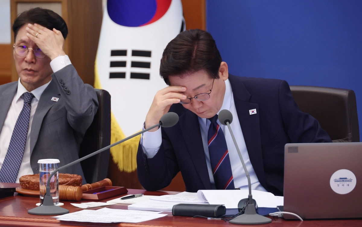 이재명 대통령이 12일 청와대에서 열린 국무회의 겸 비상경제점검회의에서 이마에 손을 짚은 채 보고를 듣고 있다. 왼쪽은 김민석 국무총리. 뉴스1