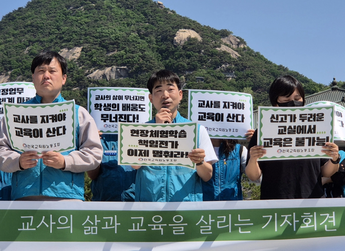 박영환(가운데) 전국교직원노동조합(전교조) 위원장이 스승의날을 하루 앞둔 14일 서울 종로구 청와대 분수대 인근에서 열린 기자회견에서 발언하고 있다. 반영윤 기자
