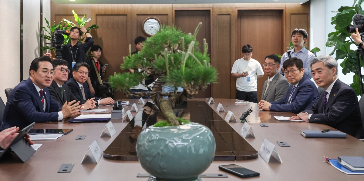 박홍근(맨 왼쪽) 기획예산처 장관이 14일 서울 중구 한국은행에서 신현송(맨 오른쪽) 한국은행 총재와 회동하며 소나무 분재 선물에 대해 설명하고 있다. 연합뉴스