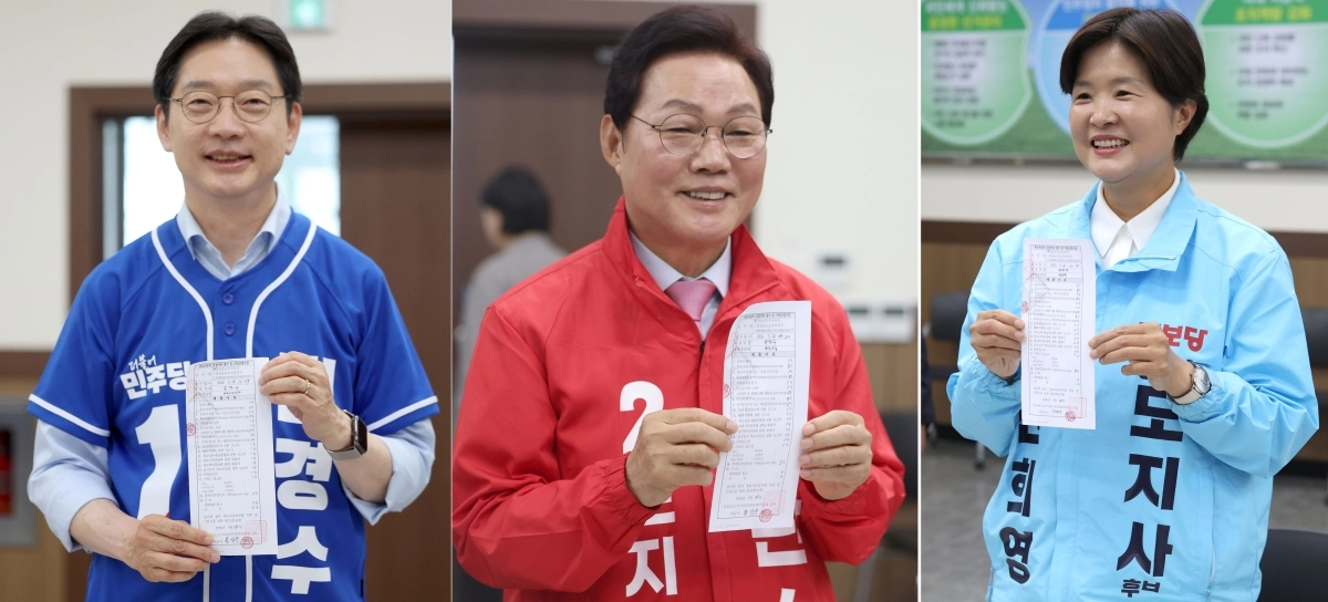 경남지사에 출마한 후보들이 14일 경남 창원시 성산구 경남도선거관리위원회에서 후보 등록을 마친 후 후보자등록 신청서류 접수 및 기탁금영수증을 취재진에게 들어 보이고 있다. 왼쪽부터 더불어민주당 김경수 후보, 국민의힘 박완수 후보, 진보당 전희영 후보(기호순). 2026.5.14. 연합뉴스