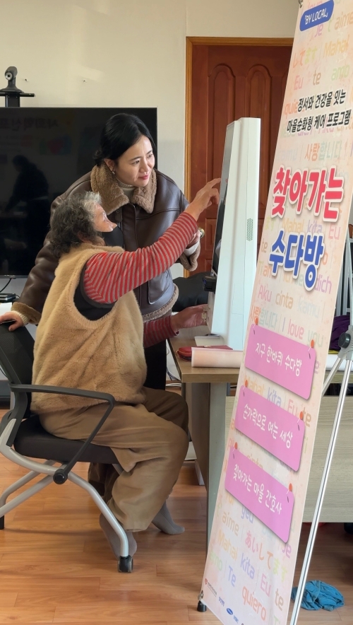 김보경 치유의파동 대표가 어르신 건강·정서 돌봄 프로그램인 ‘찾아가는 수다방’에서 한 어르신에게 키오스크 사용법을 알려 주고 있다. 치유의파동 제공
