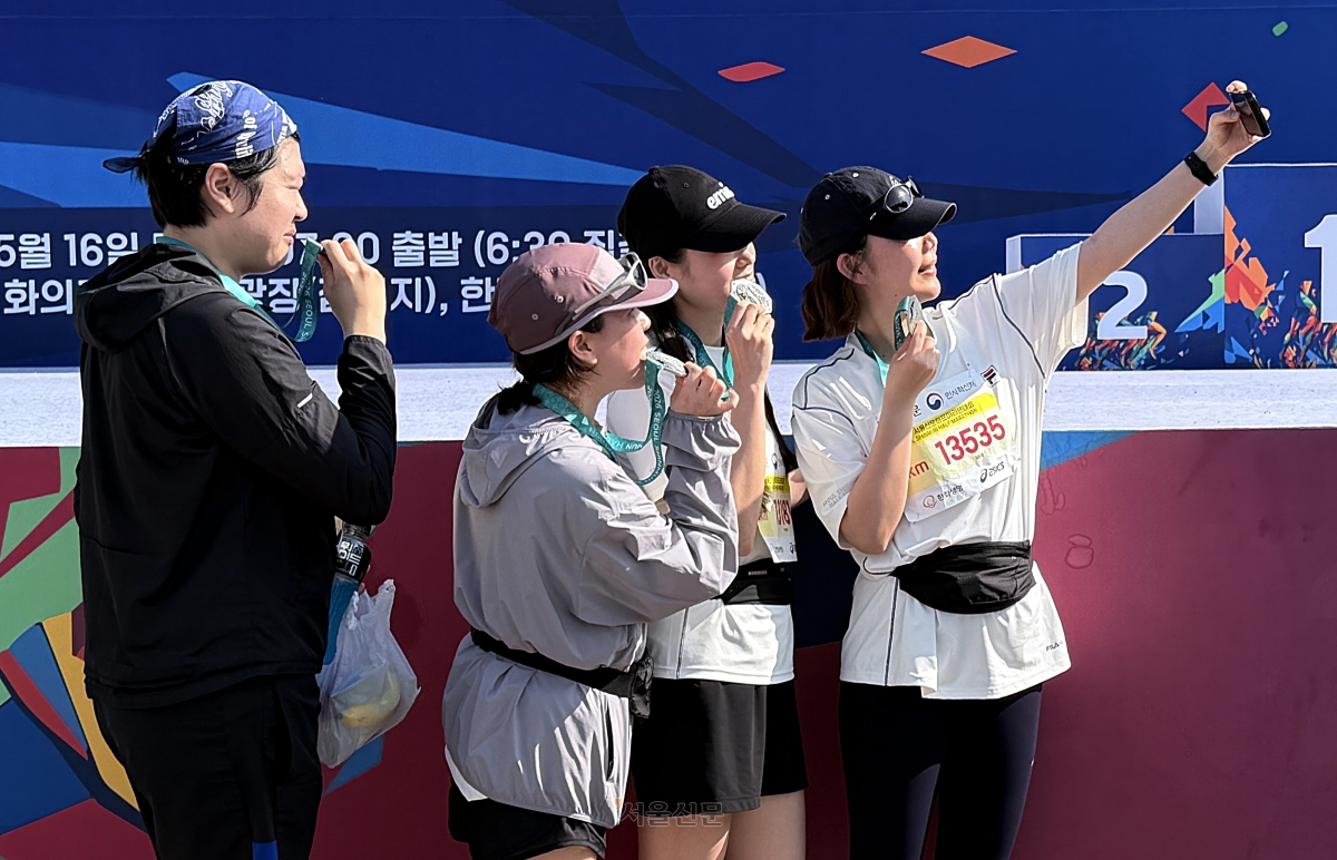16일 서울 마포구 평화광장에서 열린 2026 서울신문 하프마라톤 대회에서 참가자들이 완주 후 받은 메달을 들고 추억을 남기고 있다. 2026.5.16 이지훈 기자
