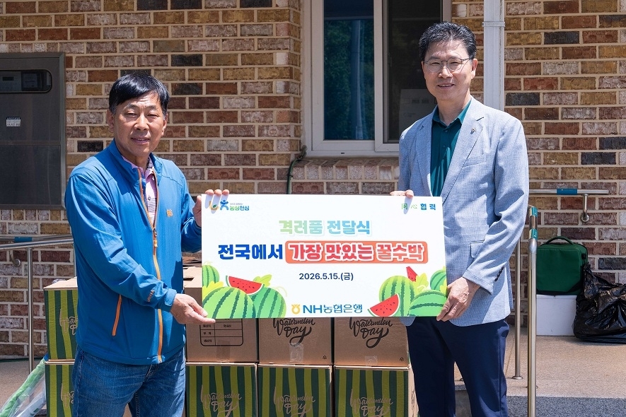 강태영(오른쪽) NH농협은행장이 지난 15일 강원 춘천시 동산면 구암마을에서 일손 돕기를 한 뒤 ﻿농산물을 전달하며 원창1리 김봉림 이장과 기념촬영을 하고 있다. 농협은행 제공