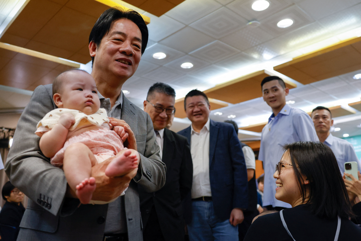 라이칭더 대만 총통이 17일 민주진보당 창당 40주년 기념 행사에서 아기를 안고 사진을 찍고 있다. 타이베이 로이터 연합뉴스