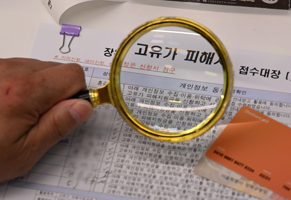 소득 하위 70% 2차 고유가 피해 지원금 신청이 시작된 18일 서울 성북구 장위3동 주민센터에서 한 고령의 신청자가 돋보기를 이용해 서류를 작성하고 있다. 2026.5.18 도준석 전문기자