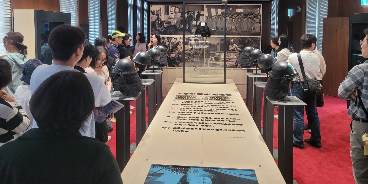 46년 만에 복원된 옛 전남도청을 찾은 시민들이 18일 전시관에서 5·18 당시 계엄군 장비와 기록물을 둘러보며 도슨트 해설을 듣고 있다.