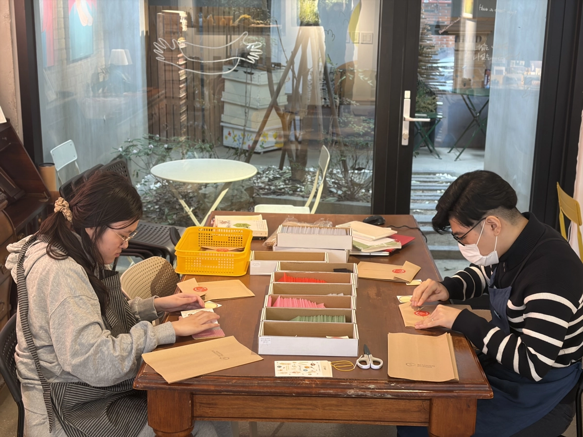 비컴프렌즈의 발달장애인 직원 이병우(오른쪽)씨와 방민지씨가 지난달 경남 양산시에 위치한 카페 ‘오봉살롱’에서 고객들에게 배송할 제품을 포장하고 있다. 비컴프렌즈 제공
