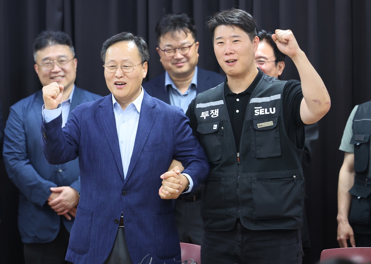 20일 경기도 수원시 장안구 경기고용노동청에서 열린 삼성전자 임금협상을 마친 후 여명구 삼성전자 DS(디바이스솔루션·반도체 사업 담당) 피플팀장과 최승호 삼성그룹 초기업노동조합 삼성전자지부 위원장이 잠정 합의한에 서명한 후 파이팅을 외치고 있다.  2026.05.20. 공동취재