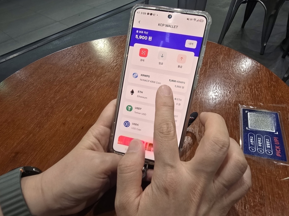 NHN KCP 임직원이 PAYCO 앱에서 PAYCO 포인트를 스테이블코인으로 결제하고 있다.