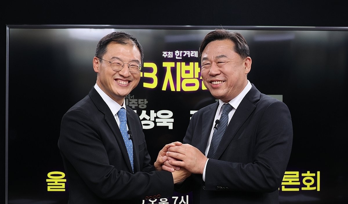 6·3 지방선거 울산시장 후보 단일화에 합의한 더불어민주당 김상욱 후보(왼쪽)와 진보당 김종훈 후보가 지난 20일 서울 마포구 한겨레 신문사에서 열린 단일화 토론회에서 손을 맞잡고 있다. 연합뉴스