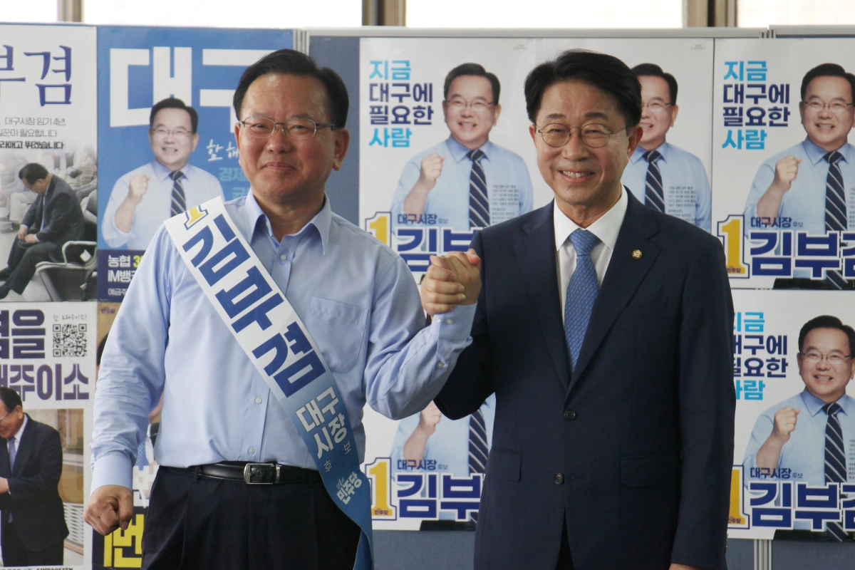 김부겸 더불어민주당 대구시장 후보와 제22대 국회 후반기 의장 후보로 선출된 조정식 민주당 의원이 25일 김 후보의 선거사무소에서 손을 맞잡고 있다. 김부겸 선거사무소 제공