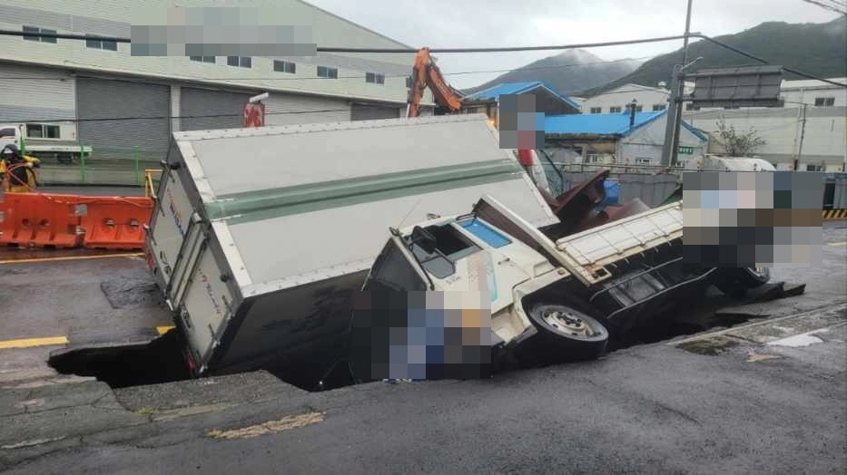 부산에 집중호우가 내린 2024년 9월 21일 오전 사상~하단선 2공구 공사현장 주변인 새벽로에 땅꺼짐이 발생해 트럭 2대가 빠져있다. 부산경찰청 제공