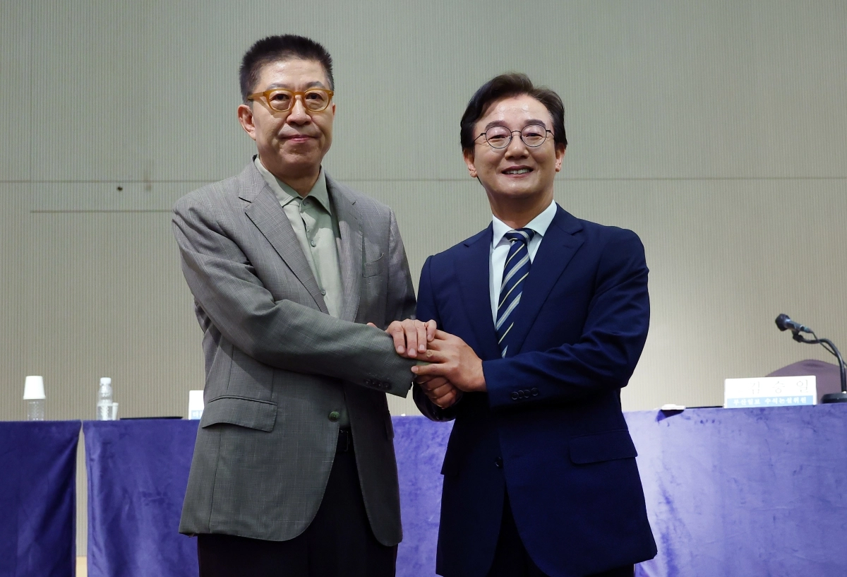 전재수(오른쪽) 더불어민주당 부산시장 후보와 박형준 국민의힘 후보가 26일 부산 동서대 센텀캠퍼스에서 진행된 관훈클럽·부산일보 주최 순차 토론회에 참석해 손을 맞잡은 채 기념촬영을 하고 있다. 부산 연합뉴스