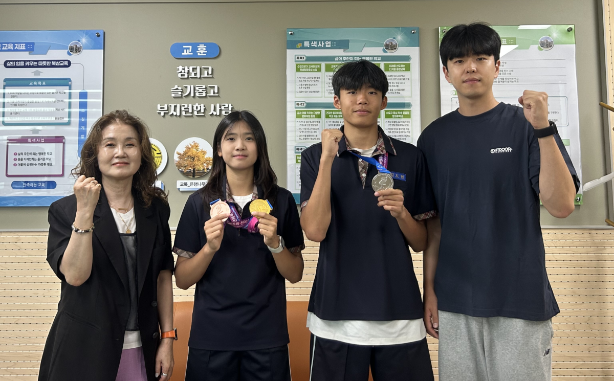 경북 칠곡 북삼중 육상부 선수들이 ‘제55회 전국소년체육대회’에서 3개의 메달을 획득하고 돌아와 기념 촬영을 하고 있다. 북삼중 제공