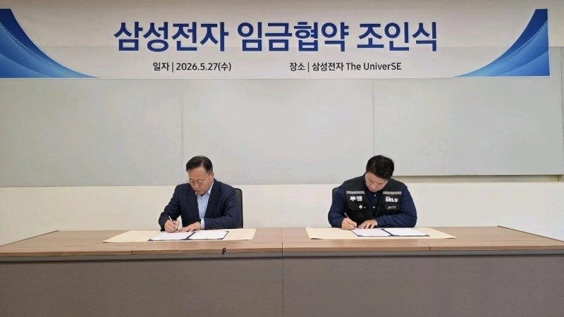 경기 용인시 기흥에 위치한 삼성전자에서 삼성전자 여명구 부사장과 삼성그룹 초기업노동조합 삼성전자 지부 최승호 위원장이 임금협약서에 서명하고 있다. 삼성그룹 초기업노조 제공