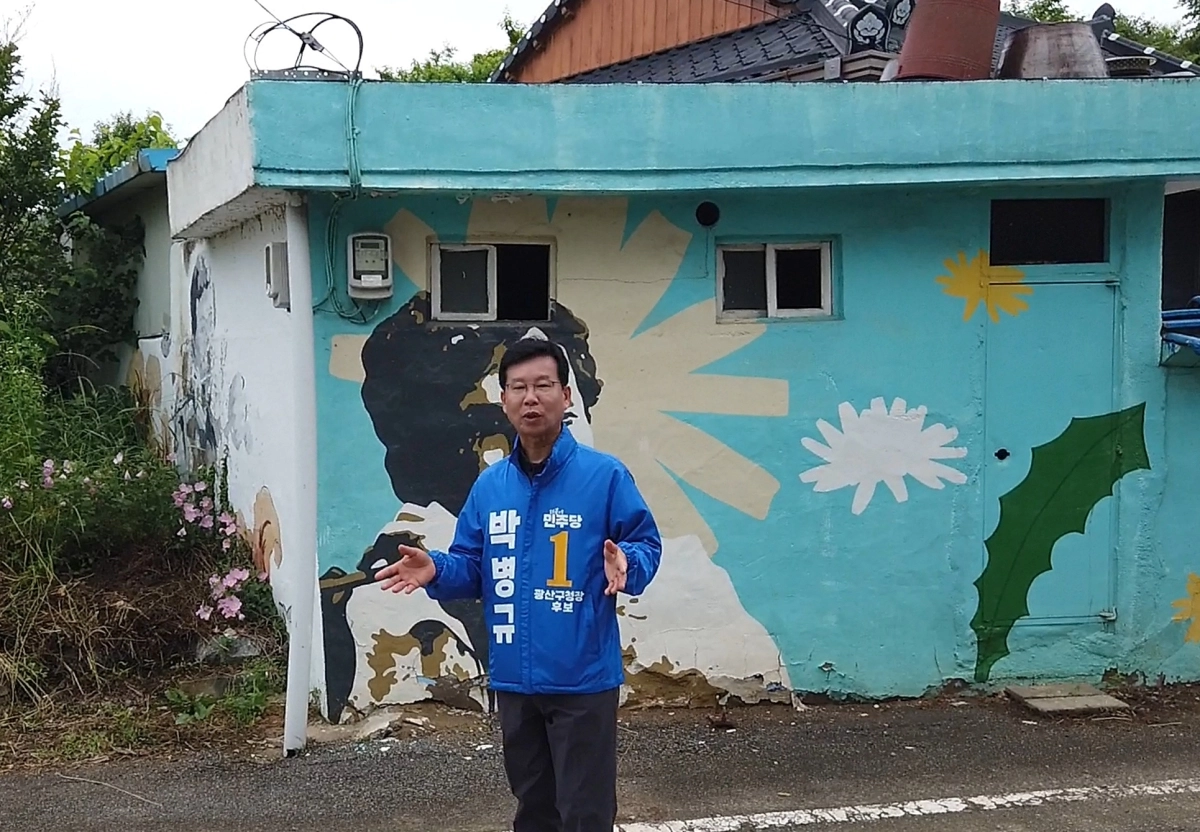 박병규 민주당 광주 광산구청장 후보가 27일 ‘윤상원민주로’를 찾아 5·18정신을 설명하고 있다. 박병규 선거사무소 제공