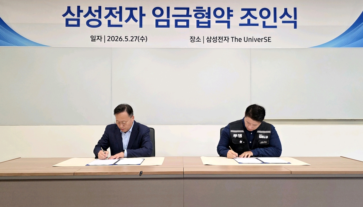 여명구(왼쪽) 삼성전자 부사장과 삼성그룹 초기업노동조합 삼성전자 지부 최승호 위원장이 27일 임금협약 조인식에서 서명하고 있다. 임금 협약은 노조 투표에서 73.3%의 찬성으로 가결됐다.
