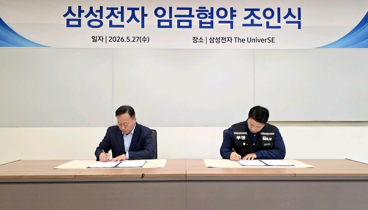 여명구(왼쪽) 삼성전자 부사장과 삼성그룹 초기업노동조합 삼성전자 지부 최승호 위원장이 27일 임금협약 조인식에서 서명하고 있다. 임금 협약은 노조 투표에서 73.3%의 찬성으로 가결됐다.