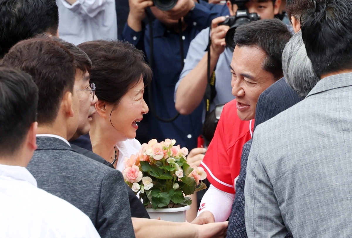 박근혜 전 대통령이 28일 강원 원주시 중앙시장을 방문해 국민의힘 김진태 강원도지사 후보로부터 꽃을 받고 있다. 2026.5.28 연합뉴스