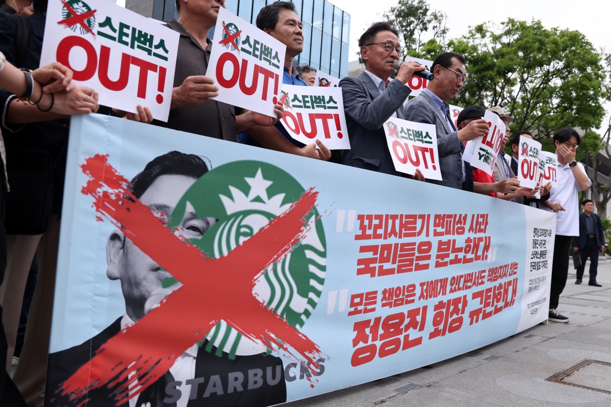 27일 서울 광화문광장에서 열린 ‘면피성 꼬리자르기 사과 정용진 회장 규탄, 스타벅스 불매운동 전국화 발표 기자회견’에서 전국민중행동 등 참석자들이 관련 현수막과 손팻말을 들고 있다. 2026.5.27 연합뉴스