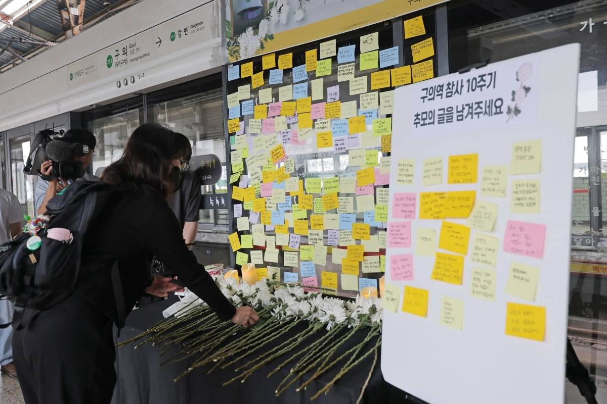 28일 서울 광진구 구의역 9-4 승강장에서 열린 ‘구의역 참사 10주기 시민추모식’에서 시민들이 10년 전 홀로 스크린도어를 수리하다 숨진 김군을 추모하고 있다. 스크린도어 앞에는 하얀 국화가 수북이 놓였고, 추모의 마음을 담은 포스트잇 200여개가 붙어 있다. 연합뉴스