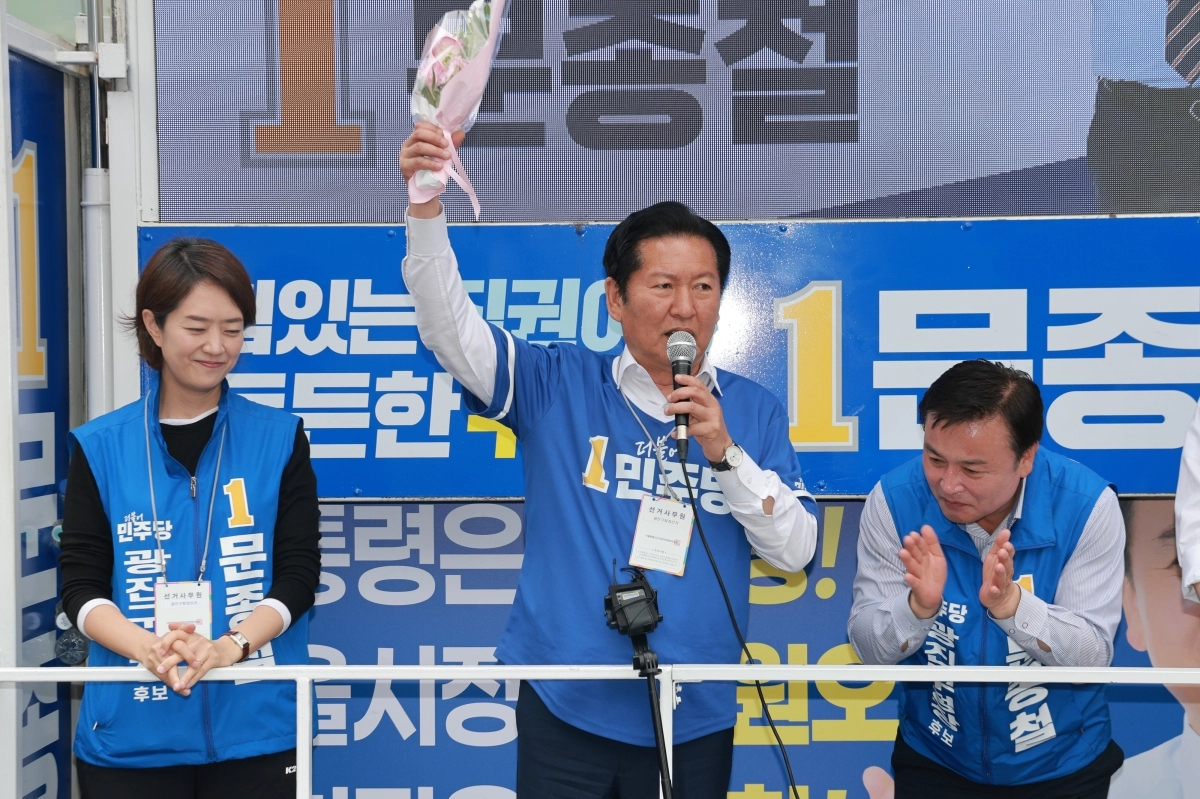 더불어민주당 정청래 총괄상임선거대책위원장이 28일 서울 광진구 건대입구역 앞 사거리에서 문종철 광진구청장 후보 지원 유세를 하는 가운데 한 시민으로부터 꽃다발을 받아 들어올려 보이고 있다. 2026.5.28. 연합뉴스