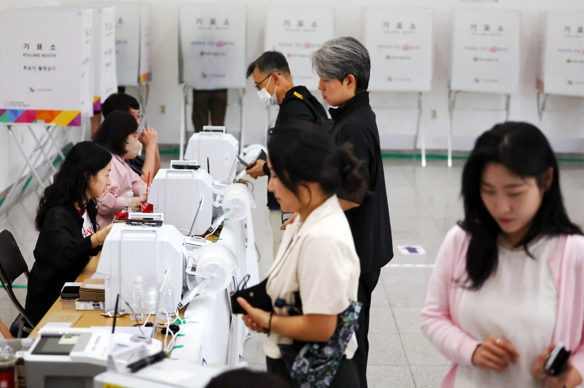 6·3 지방선거 사전투표 첫날인 29일 오전 광주 북구 전남대학교 컨벤션홀에 마련된 사전투표소에서 유권자들이 투표용지를 건네받고 있다. 연합뉴스 제공