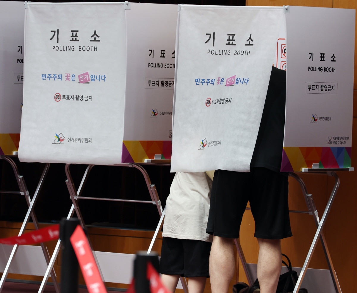 제9회 전국동시지방선거 사전투표 둘째날인 30일 전북도청에 마련된 사전투표소에서 한 어린이가 아빠의 투표 모습을 지켜보고 있다. 2026.5.30 연합뉴스