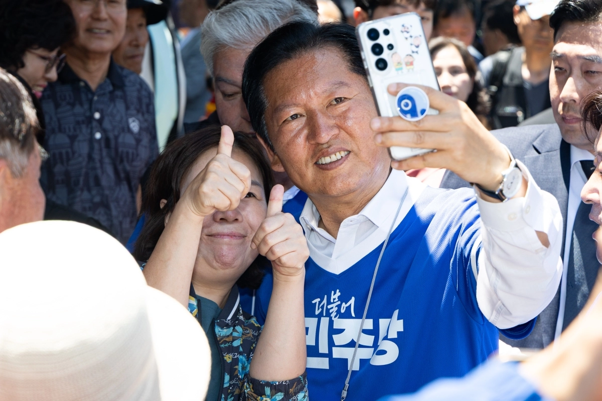 6·3 지방선거 본투표를 사흘 앞둔 31일 정청래 더불어민주당 대표가 충남 금산군 금산약초시장 앞에서 문정우 민주당 금산군수 후보 지원유세를 마치고 시민들과 기념 촬영을 하고 있다. 금산 뉴스1