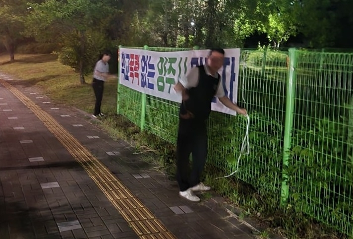 신원이 확인되지 않은 남성 2명이 양주 옥정신도시 등에 ‘학교폭력 없는 양주시 만들자’는 내용의 현수막을 게시하고 있다. [정덕영 더불어민주당 양주시장 후보 측 제공]