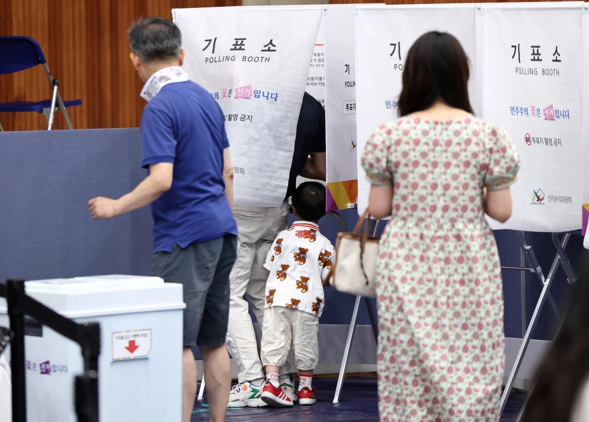 제9회 전국동시지방선거일인 3일 서울 잠전초등학교 체육관에 마련된 잠실본동 제4,5,6투표소에서 한 어린이가 투표하는 아빠를 보고 있다. 2026.6.3 연합뉴스