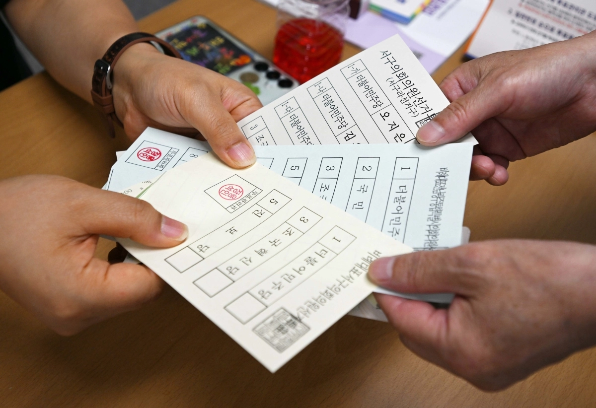 제9회 전국동시지방선거 본투표날인 3일 오전 광주 상무2동 제2투표소(쌍촌종합사회복지관)에서 한 유권자가 본인확인을 거친 후 투표 용지를 받고 있다. 2026.06.03. 뉴시스