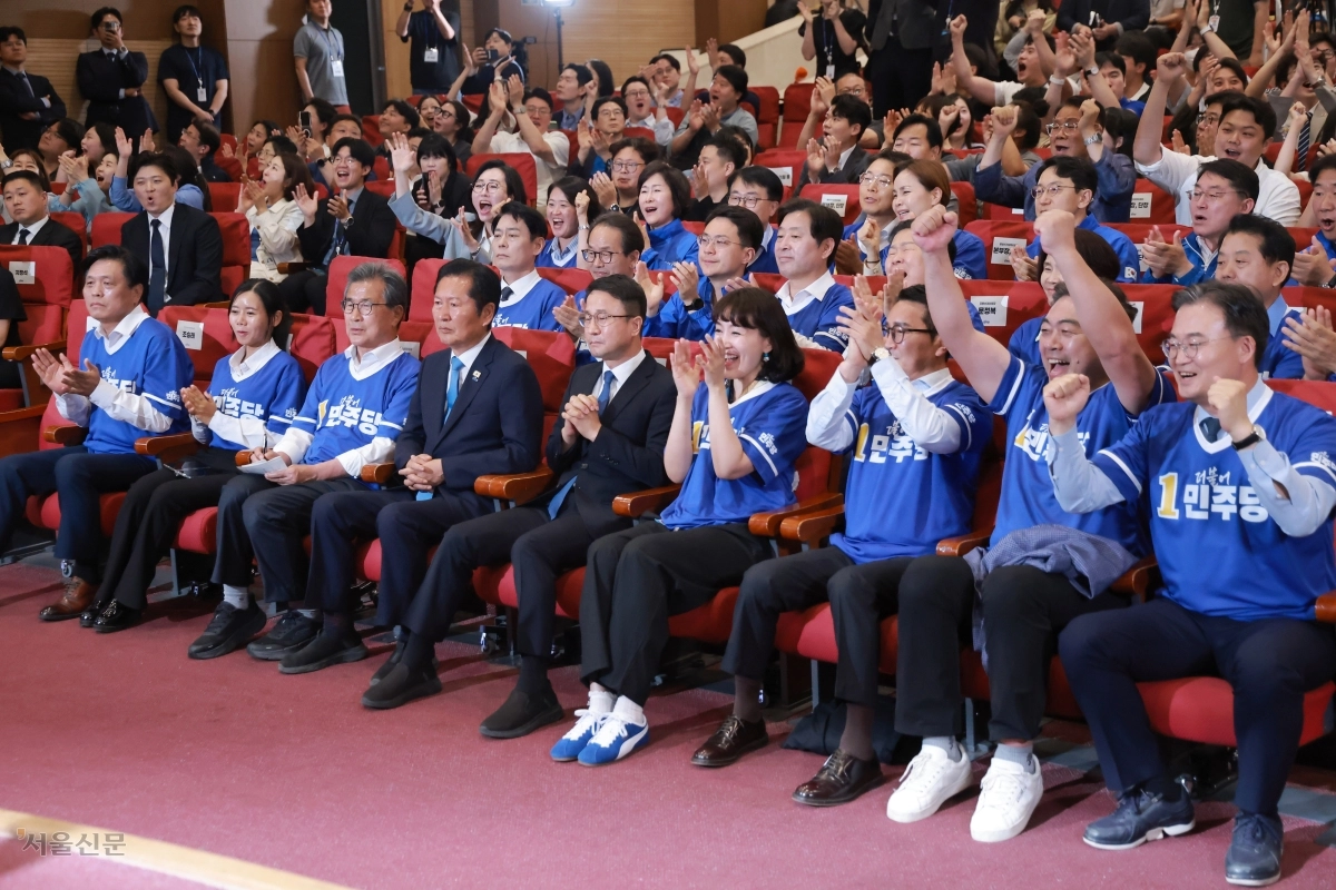 더불어민주당 정청래(왼쪽 네 번째) 대표와 한병도(다섯 번째) 원내대표가 3일 국회 의원회관에 마련된 개표상황실에서 광역단체장 16곳 가운데 11곳에서 승리할 것으로 예상되는 방송3사 출구조사 결과가 발표되자 환호하는 분위기 속에서도 신중한 표정으로 지켜보고 있다. 안주영 전문기자