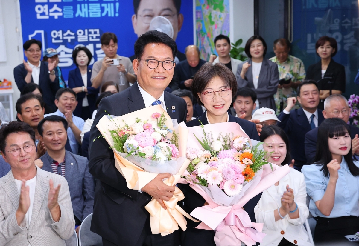 송영길(왼쪽) 더불어민주당 인천 연수갑 국회의원 보궐선거 후보와 부인 남영신씨가 4일 인천 연수구 선거 사무소에서 당선이 유력해지자 꽃다발을 든 채 기념촬영을 하고 있다.  인천 연합뉴스