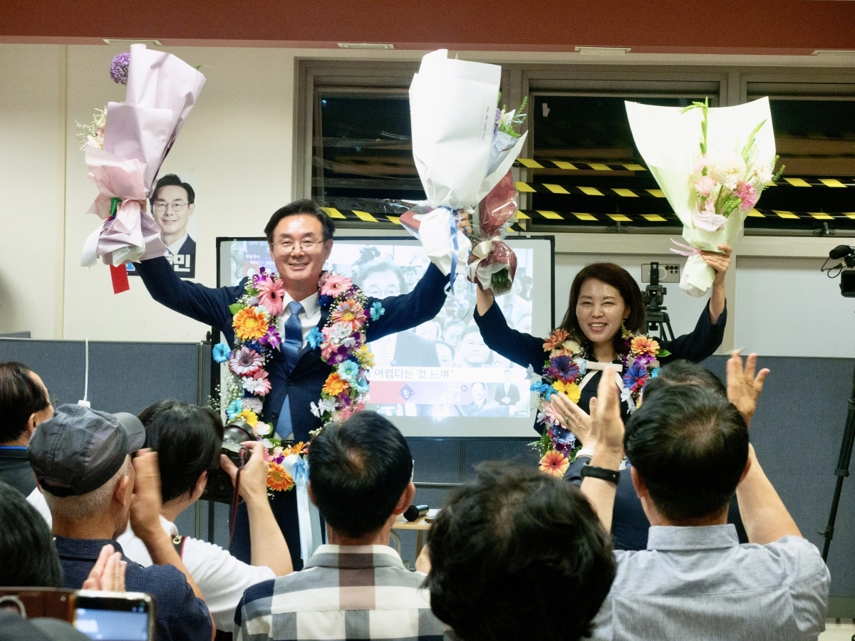 최동민(왼쪽) 더불어민주당 서울 동대문구청장 후보가 당선이 확실시된 4일 새벽 서울 동대문구 제기동에 마련된 선거사무실에서 꽃목걸이를 걸고 세리머니를 하고 있다. 캠프 제공