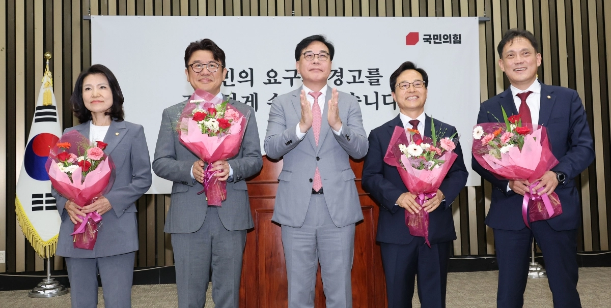국민의힘 송언석 원내대표와 6·3 재보궐선거에서 당선된 의원들이 5일 국회에서 열린 의원총회에서 두 손을 맞잡고 기념 촬영을 하고 있다. 왼쪽부터 대구 달성 이진숙 의원, 경기 평택을 유의동 의원, 송 원내대표, 충남 공주ㆍ부여ㆍ청양 윤용근 의원, 울산 남갑 김태규 의원. 연합뉴스