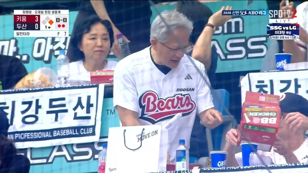 젠슨 황 엔비디아  CEO가 7일 서울 잠실야구장에서 시구를 마친 뒤 단체 괌람석에서 BBQ치킨을 먹고 있다. 중계화면 캡처