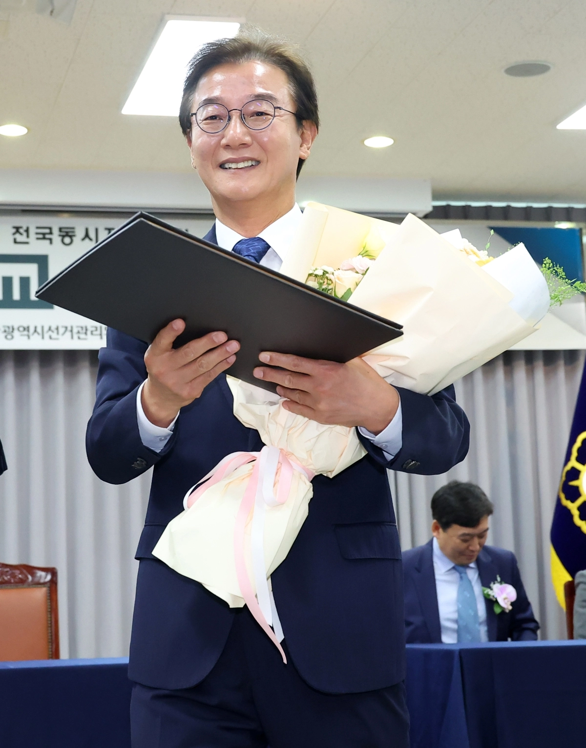 전재수 부산시장 당선인이 5일 부산 연제구 부산시선관위에서 열린 당선증 교부식에서 당선증을 받고 자리로 돌아가고 있다. 연합뉴스