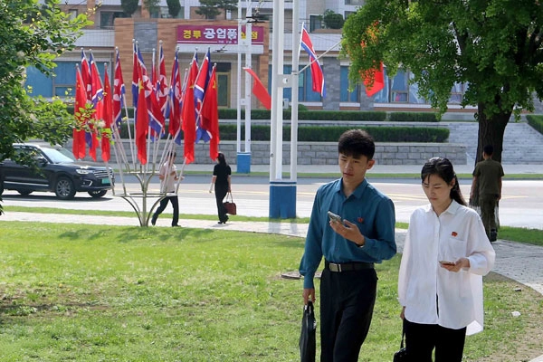8일 북한 평양에서 주민들이 중국 오성홍기와 북한 인공기가 나란히 걸린 거리를 지나고 있다. <br>AP 연합뉴스
