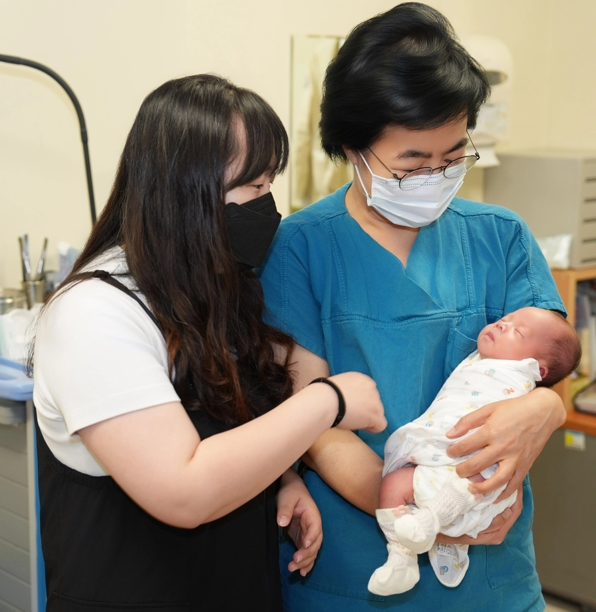 국내 최장기간인 152일의 지연 간격 분만 끝에 출산에 성공한 산모(왼쪽)와 고현선 서울성모병원 권역모자의료센터 산모태아부센터장이 아기를 안고 환하게 웃고 있다. 서울성모병원 제공